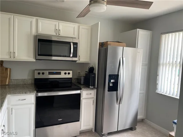 a kitchen with refrigerator and microwave