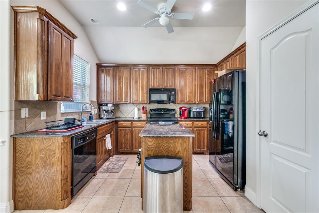 8233 Edgepoint Trail Fort Worth, TX 76053 - Photo 14 of 36 a kitchen with granite countertop stainless steel appliances a stove refrigerator and microwave