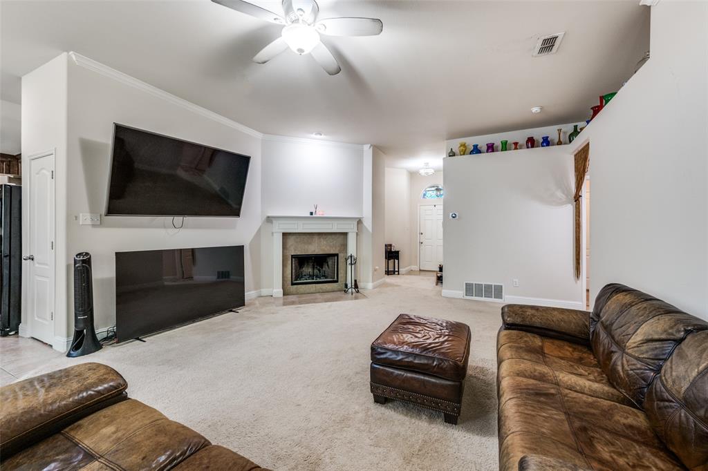8233 Edgepoint Trail Fort Worth, TX 76053 - Photo 6 of 36 a living room with furniture a fireplace and a flat screen tv