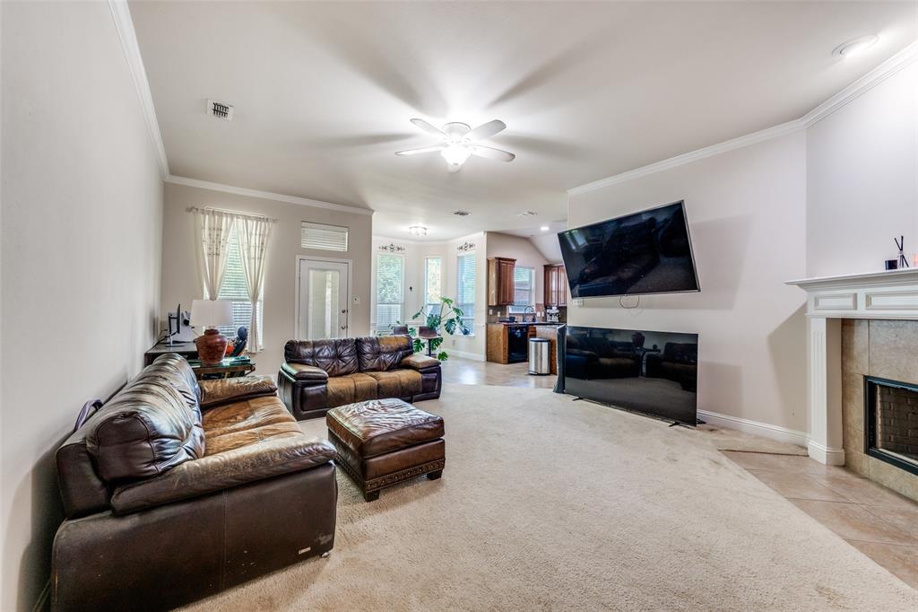 8233 Edgepoint Trail Fort Worth, TX 76053 - Photo 8 of 36 a living room with furniture a fireplace and a flat screen tv