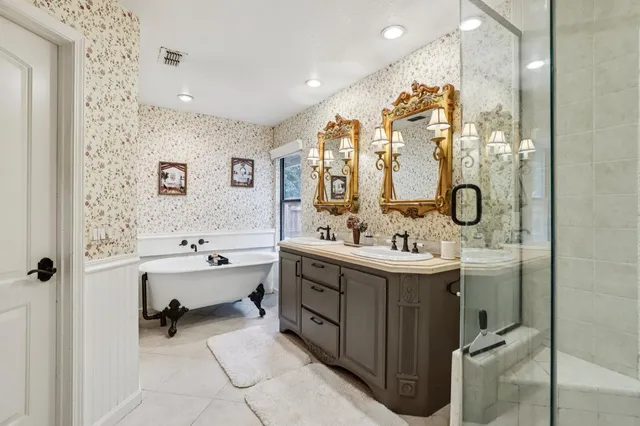 a bathroom with a double vanity sink mirror and bathtub