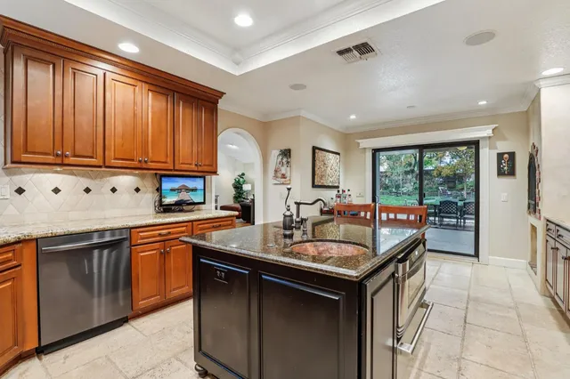 a kitchen with granite countertop a sink stove and cabinets