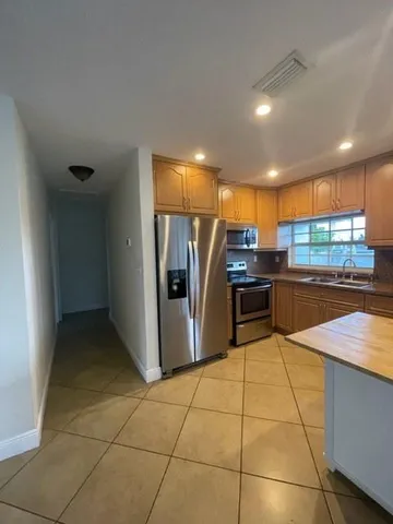 a kitchen with stainless steel appliances a refrigerator and a counter top space