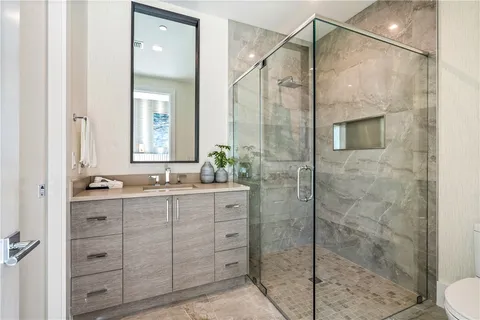 a bathroom with a granite countertop sink a toilet and shower