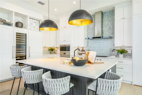 a kitchen with stainless steel appliances kitchen island granite countertop a table chairs and a wooden floor