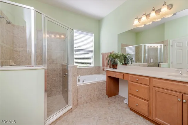 a spacious bathroom with a double vanity sink a large mirror a shower and bathtub