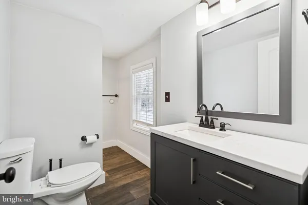 a bathroom with a toilet a sink and mirror