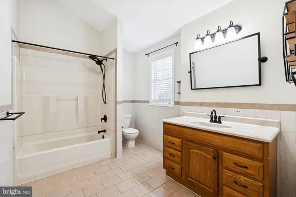 a bathroom with a sink vanity mirror bathtub and a shower