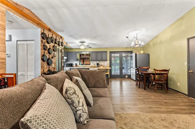 a living room with furniture flat screen tv and a large window