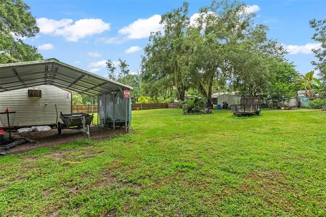 an aerial view of residential houses with outdoor space and trees all around
