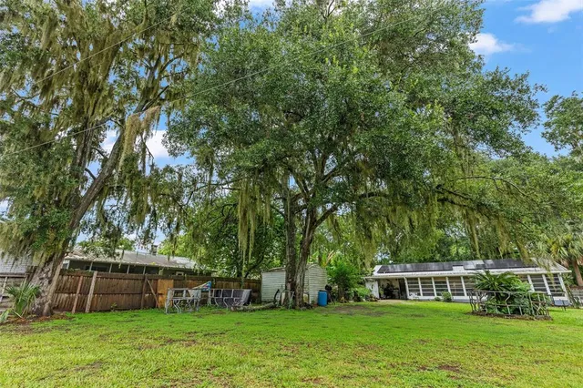 a view of a house with backyard and trees
