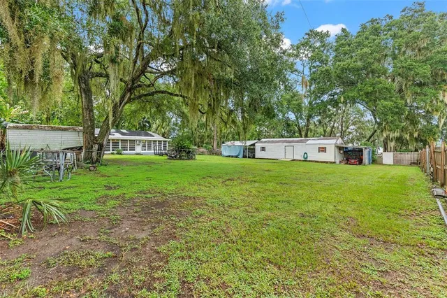 a view of a house with backyard and a tree