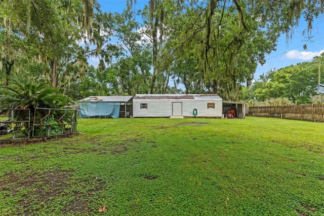 a front view of a house with a garden and trees