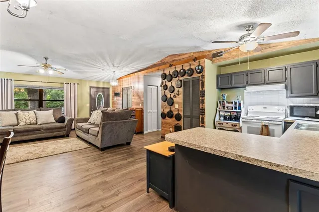 a living room with stainless steel appliances kitchen island granite countertop furniture and a large window