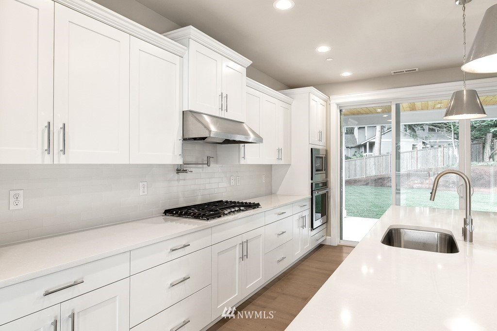 22925 31st Avenue Southeast Bothell, WA 98021 - Photo 2 of 11 a kitchen with stainless steel appliances a white stove top oven a sink a chimney and cabinets