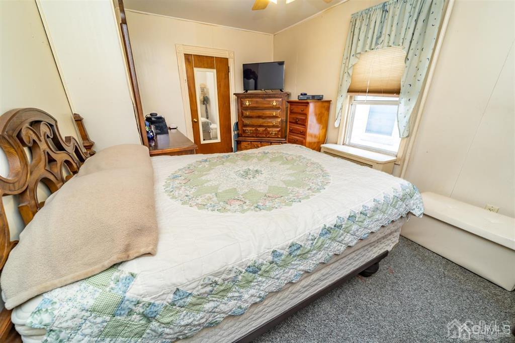 28 Niles Street Elizabeth, NJ 07202 - Photo 14 of 35 a bedroom with a bed and a mirror on the dresser