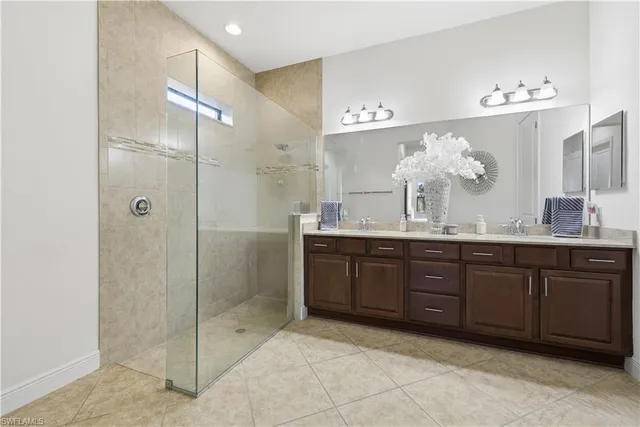 a spacious bathroom with a granite countertop sink a mirror and a shower