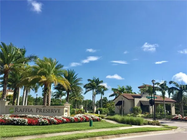 a view of a swimming pool with a lawn chairs and palm trees