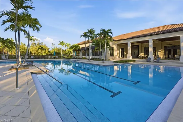 a view of swimming pool with trees and wooden fence