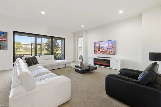 a living room with furniture and a floor to ceiling window
