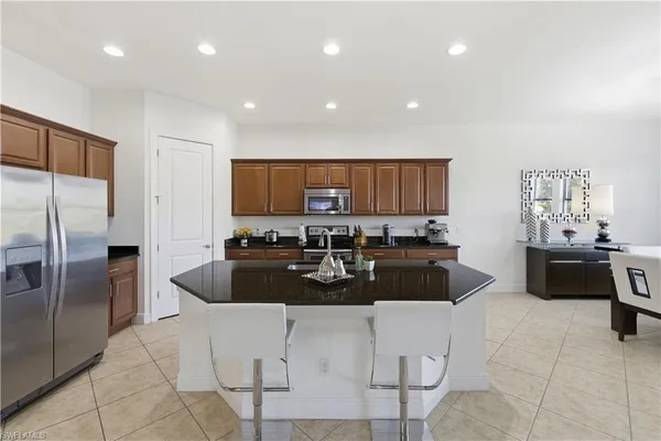 a kitchen with stainless steel appliances granite countertop a sink a stove and a refrigerator