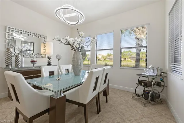a dining room with furniture a large window and a chandelier
