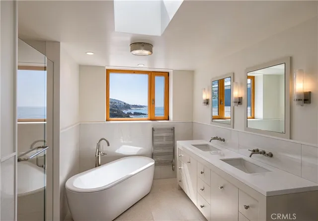 a bathroom with a double vanity sink double mirror and toilet