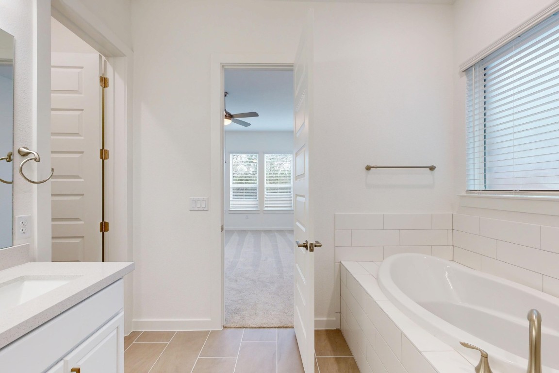 3944 Fulton Drive Leander, TX 78641 - Photo 12 of 23 a bathroom with a tub a sink and a window
