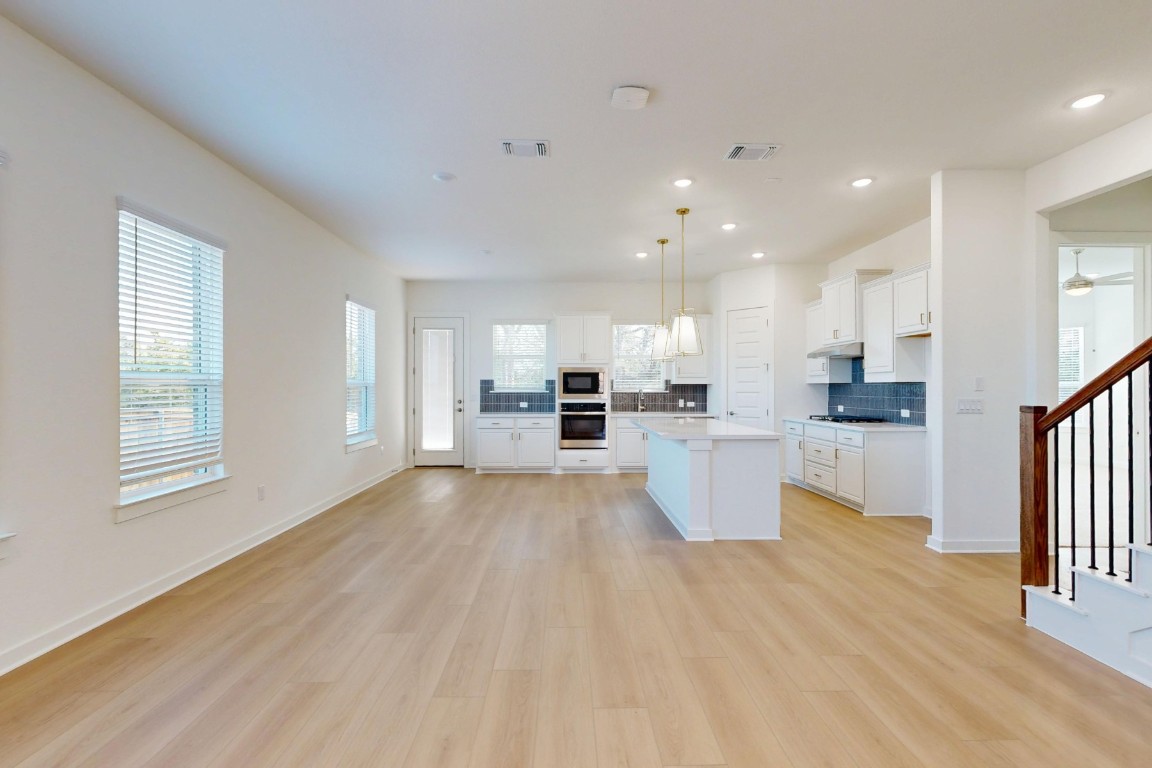 3944 Fulton Drive Leander, TX 78641 - Photo 4 of 23 a view of open kitchen with kitchen island wooden floors and center island