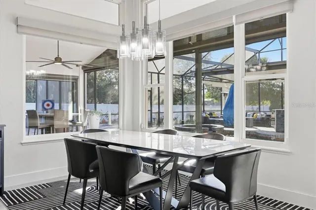 a dining room with wooden floor a chandelier a wooden table and chairs