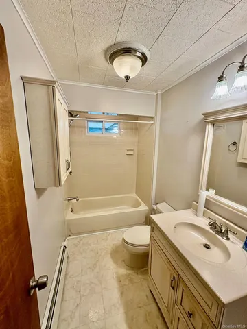 a bathroom with a tub sink toilet and a mirror