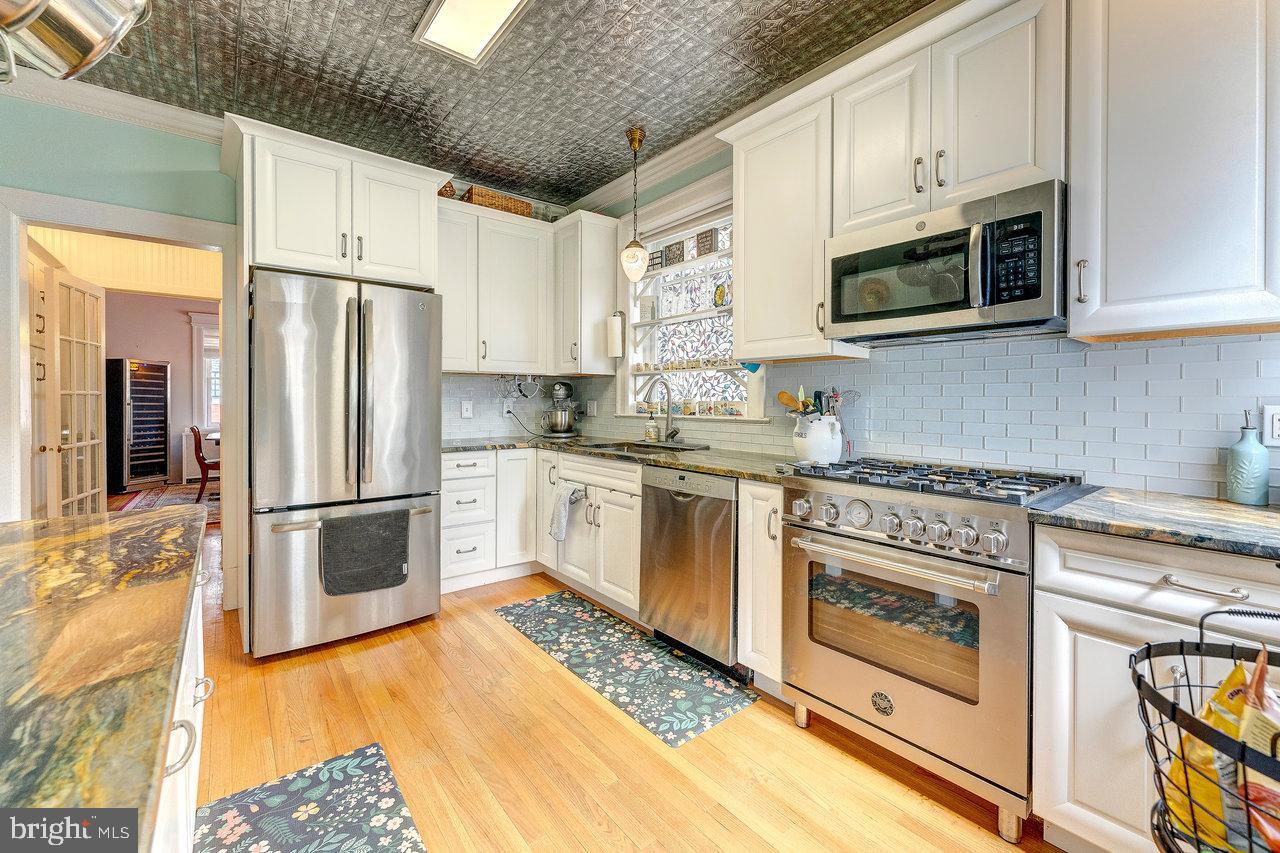 925 Berkeley Avenue Trenton, NJ 08618 - Photo 12 of 36 a kitchen with stainless steel appliances white cabinets and a stove top oven