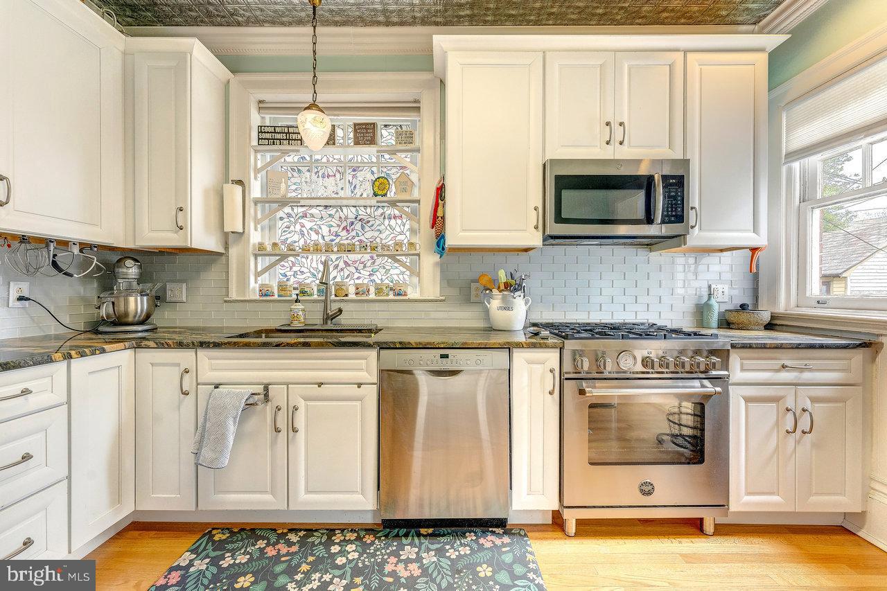 925 Berkeley Avenue Trenton, NJ 08618 - Photo 14 of 36 a kitchen with stainless steel appliances granite countertop a stove a sink and a microwave