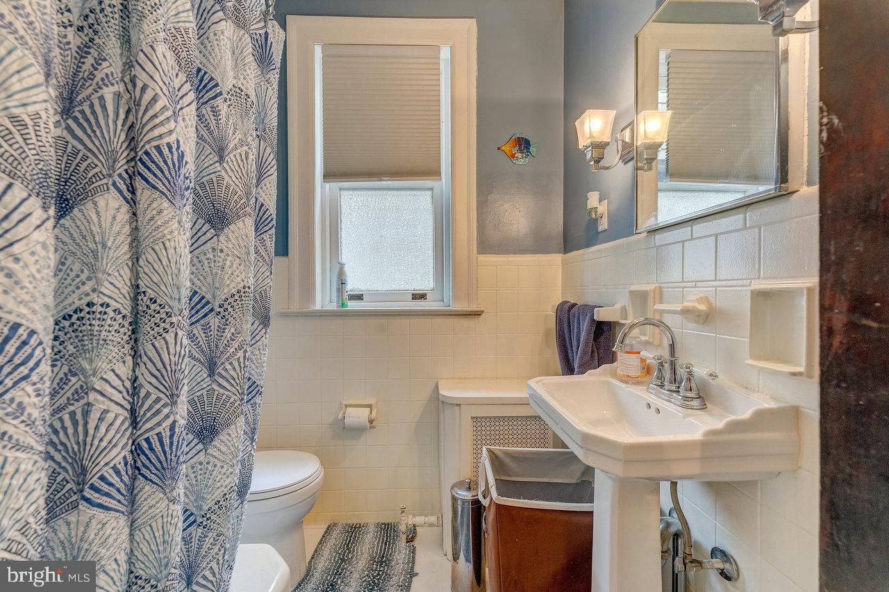 925 Berkeley Avenue Trenton, NJ 08618 - Photo 19 of 36 a bathroom with a sink a toilet and a mirror