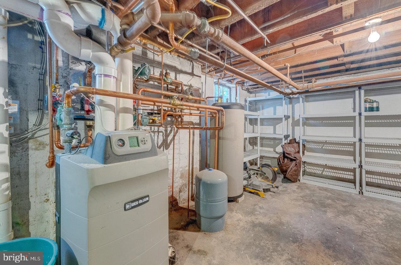 925 Berkeley Avenue Trenton, NJ 08618 - Photo 27 of 36 a view of a storage room with water heater and racks