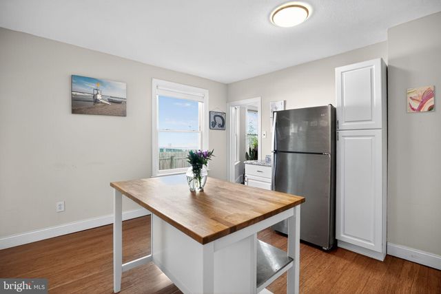 a kitchen with stainless steel appliances granite countertop a refrigerator a stove a sink and a wooden floor