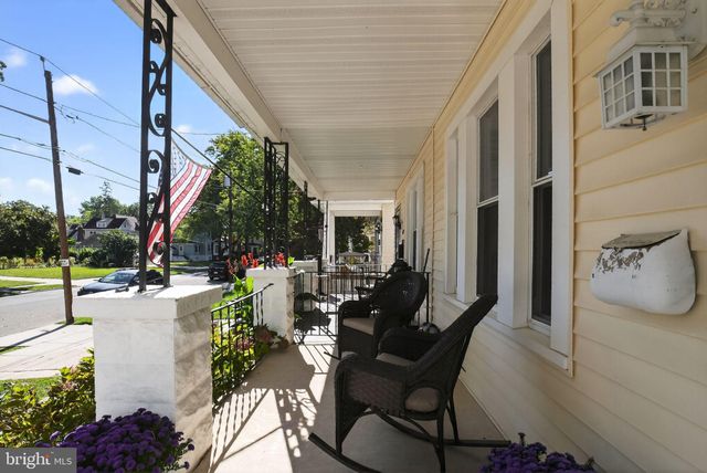a view of a patio with couches table and chairs potted plants and large tree