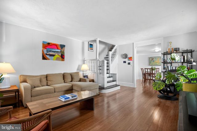 a living room with furniture stairs and a potted plant