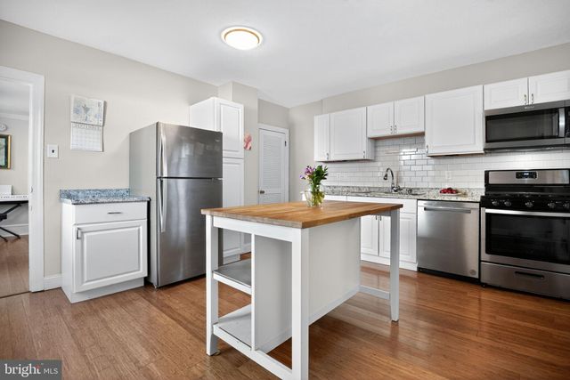 a kitchen with a refrigerator a stove top oven a sink and cabinets