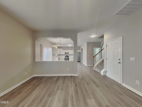 a view of a big room with wooden floor and windows
