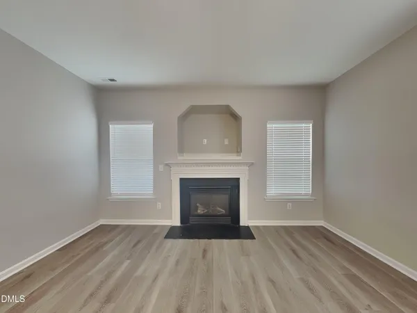 a view of an empty room with a fireplace and a window