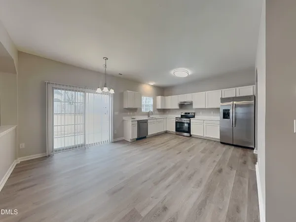 a view of a kitchen with wooden floor and windows