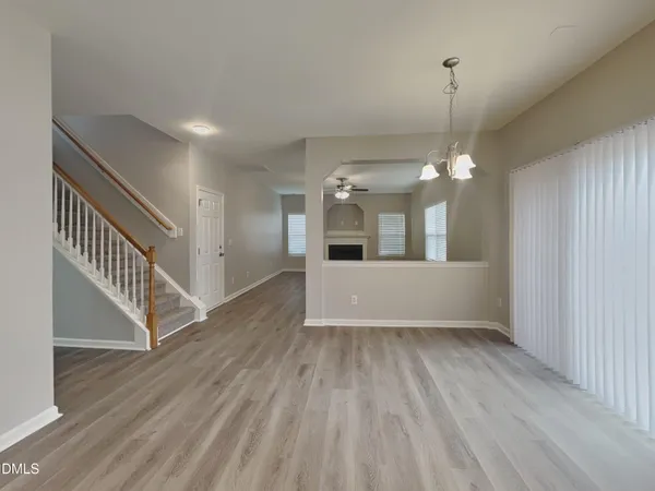 a view of a room with wooden floor staircase and a kitchen