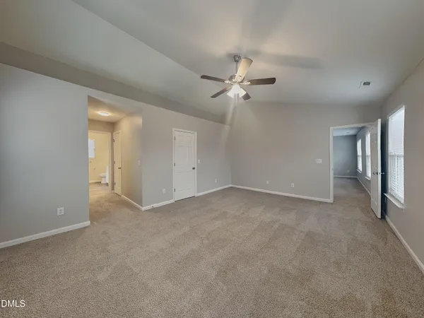 a view of an empty room with a ceiling fan