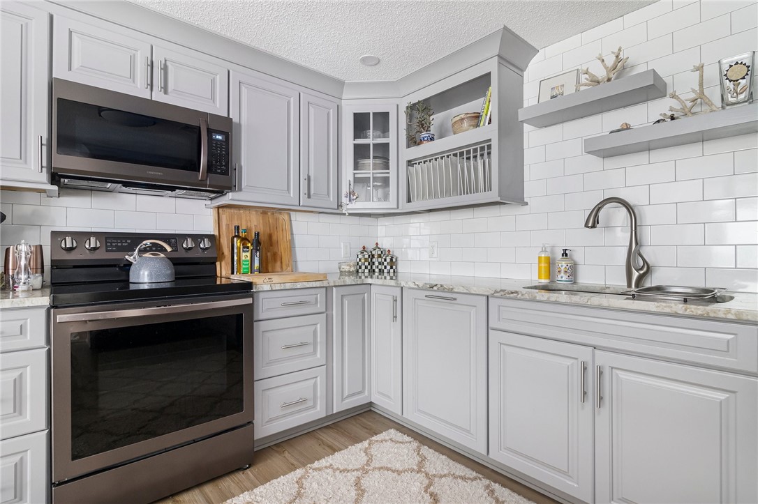 5390 Post Road, Unit 4 East Greenwich, RI 02818 - Photo 11 of 35 Featuring tons of storage, ample prep space, granite countertops and stylish, subway tile.