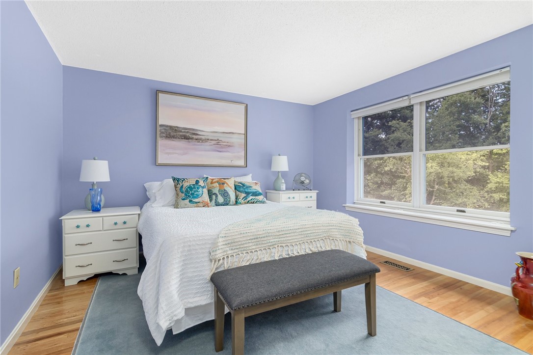 5390 Post Road, Unit 4 East Greenwich, RI 02818 - Photo 17 of 35 The first of two, large bedrooms on the second level shows beautiful, hardwood floors and oversize windows for lots of natural light.