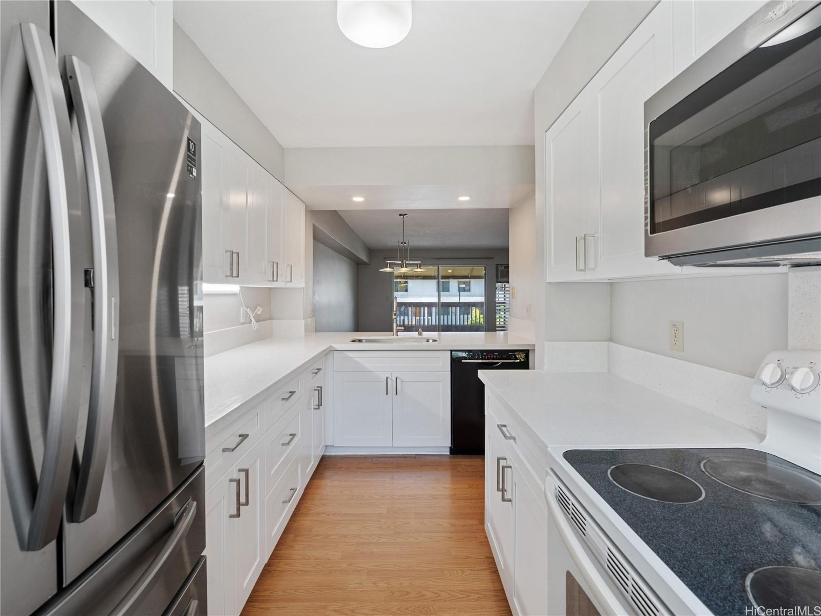 98-941 Moanalua Road, Unit 403 Aiea, HI 96701 - Photo 2 of 25 a kitchen with white cabinets and stainless steel appliances