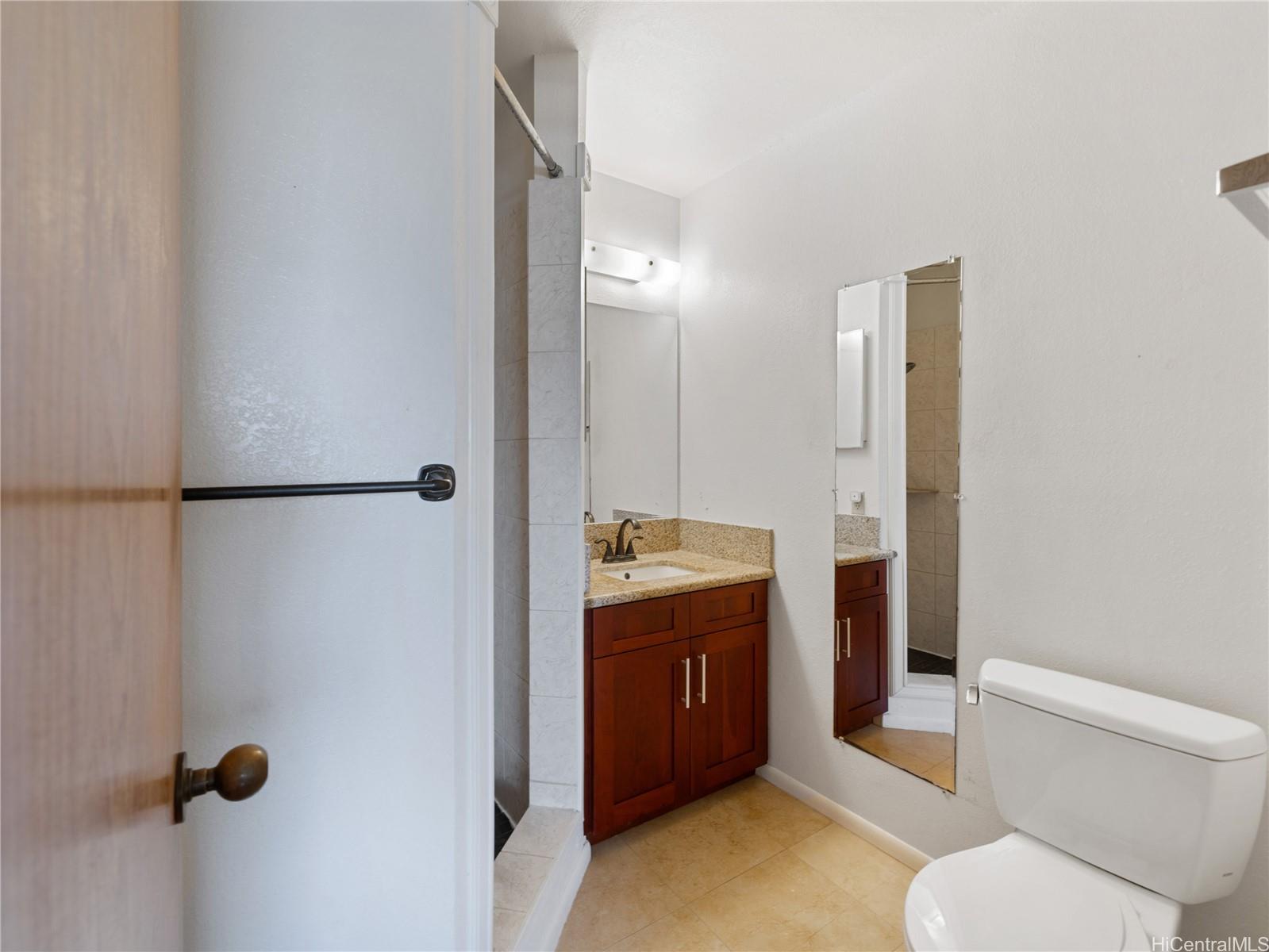 98-941 Moanalua Road, Unit 403 Aiea, HI 96701 - Photo 9 of 25 a spacious bathroom with a granite countertop sink mirror vanity and toilet