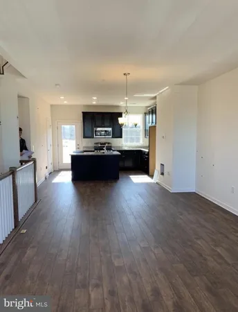 a living room with kitchen island granite countertop wooden floors and a fireplace