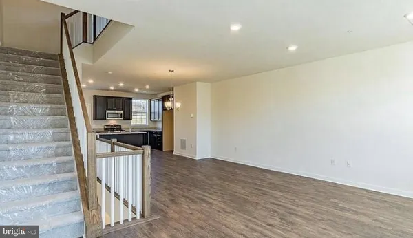 a view of kitchen with kitchen island stainless steel appliances refrigerator sink and stove with wooden floor